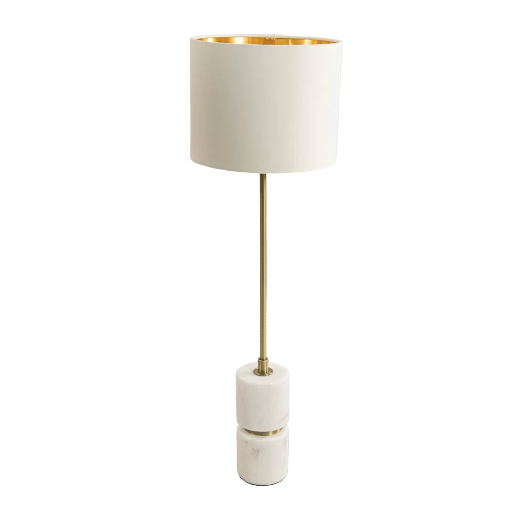 A tall table lamp with a white marble base, antique brass finish, and an opal fabric shade.