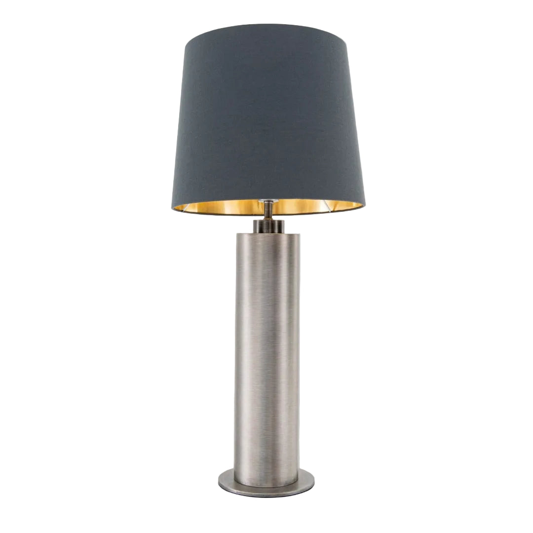 A contemporary table lamp with a brushed gunmetal finish and a charcoal-colored shade with a gold inner lining.