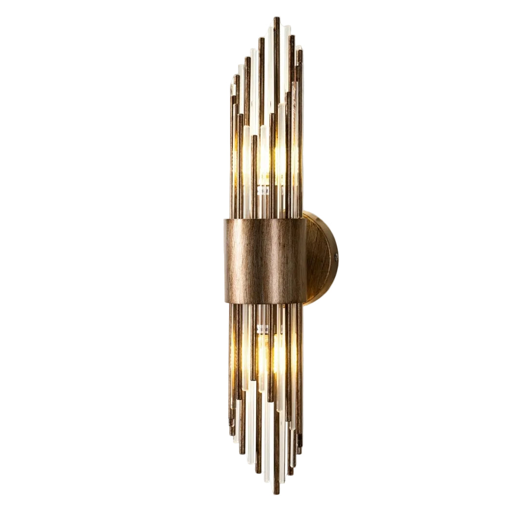 A modern wall lamp with multiple vertical rods in antique gold finish and glass elements, providing a warm glow.