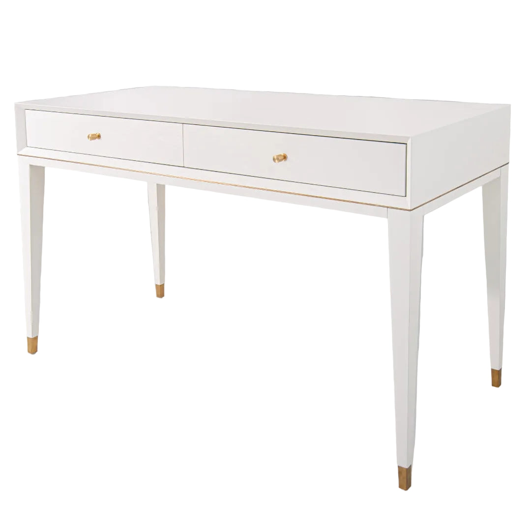 A white dressing table with brass accents and gold handles, featuring a sleek design with drawers and metal legs.