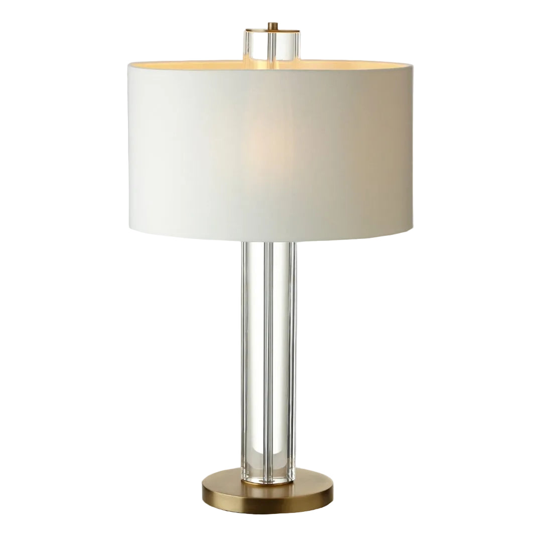 A tall table lamp with a crystal base, antique brass finish detailing, and a soft opal fabric shade.