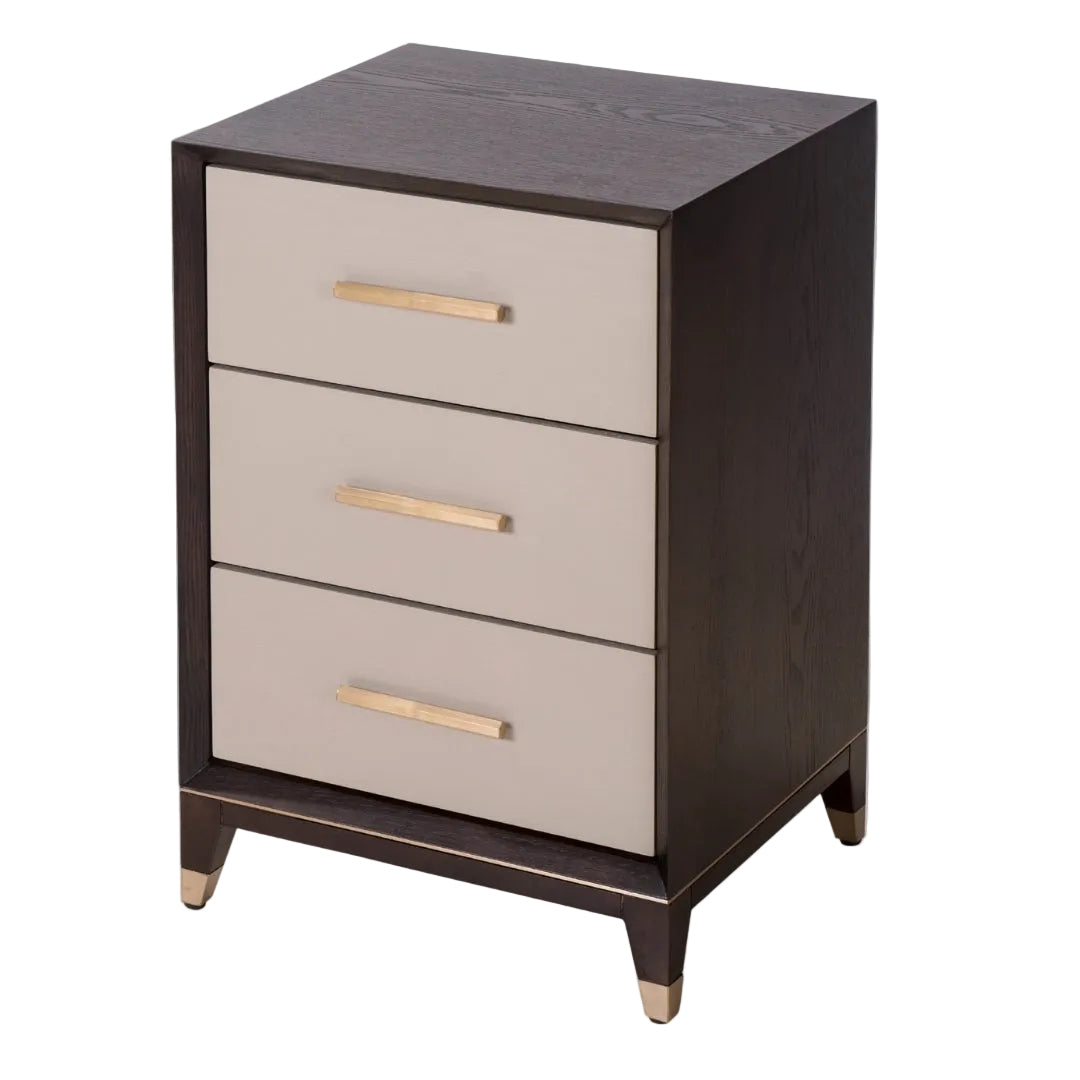 A Cairo Bedside Table with three drawers, featuring a painted veneer finish in ceramic grey and chocolate, with antique brass handles.