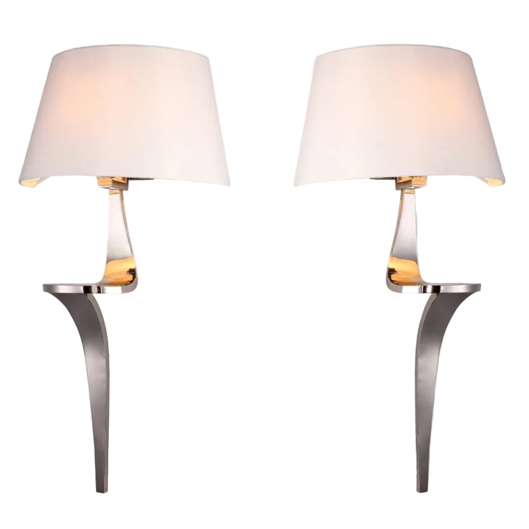 A pair of wall-mounted lamps with polished nickel finish and cream fabric shades.