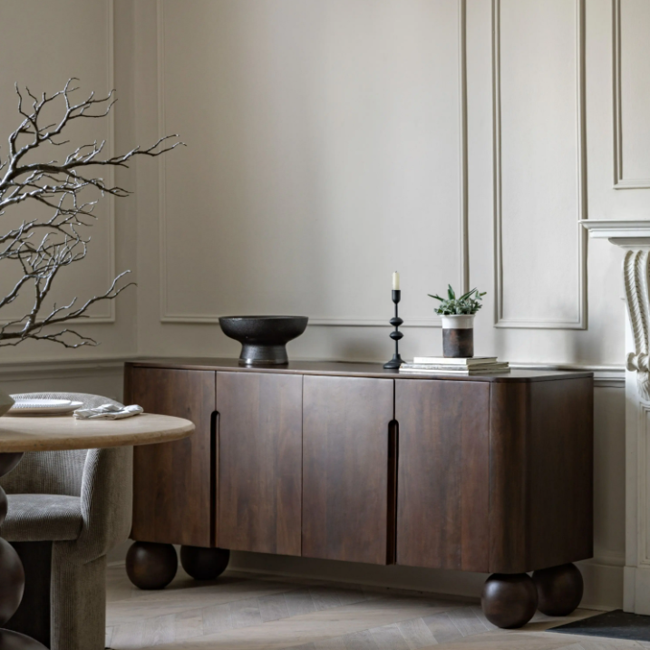Wooden sideboard in a dining room setting with decor elements.