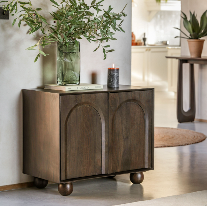 Wooden sideboard with decorative items in a home setting