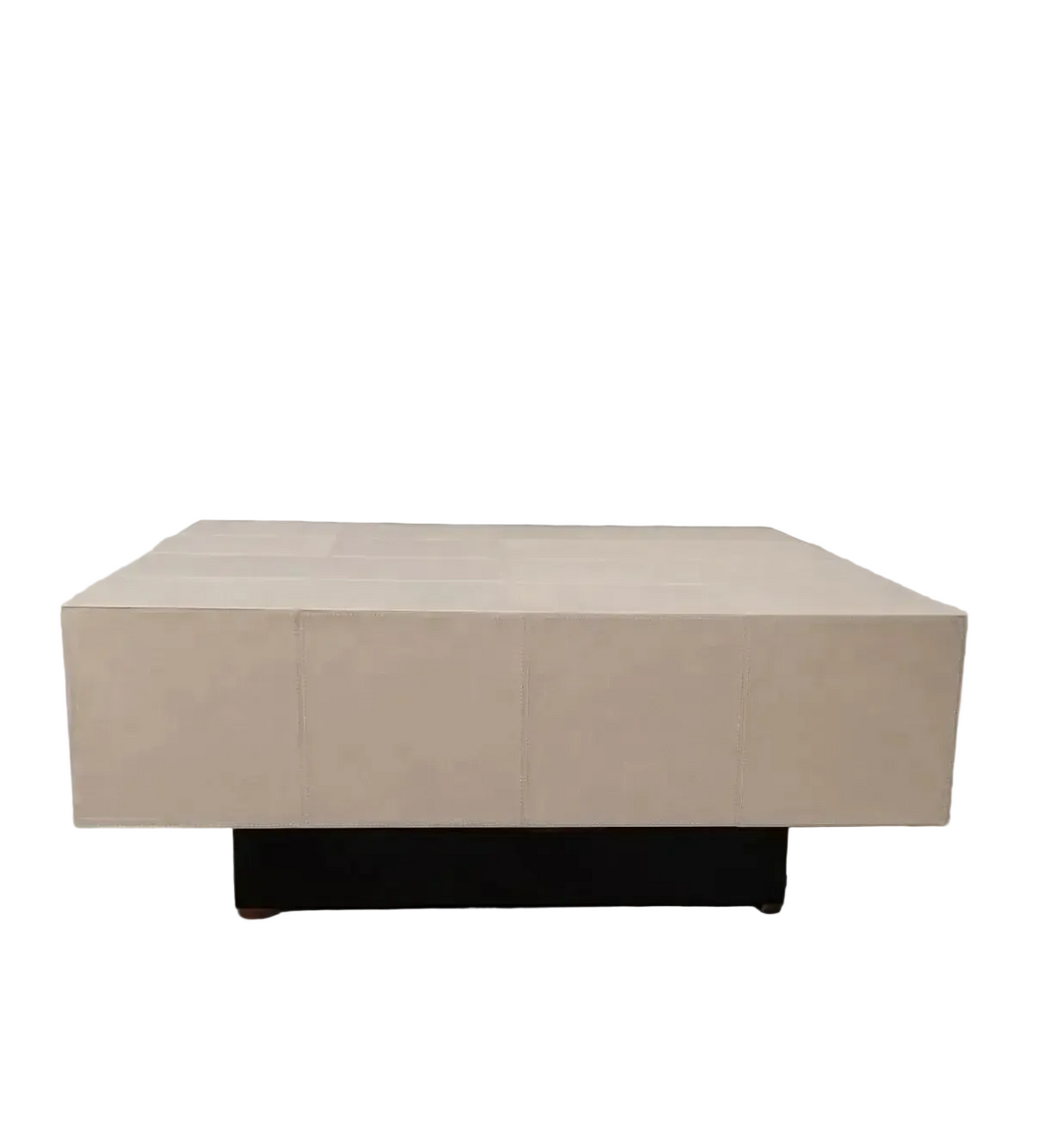 A modern square coffee table with a light beige stone or concrete top and a dark black base, set against a neutral gray background.