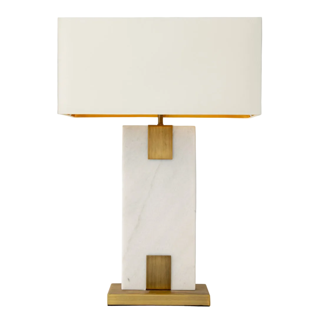 An elegant table lamp with a white marble base, antique brass accents, and a opal fabric shade, providing a warm glow.