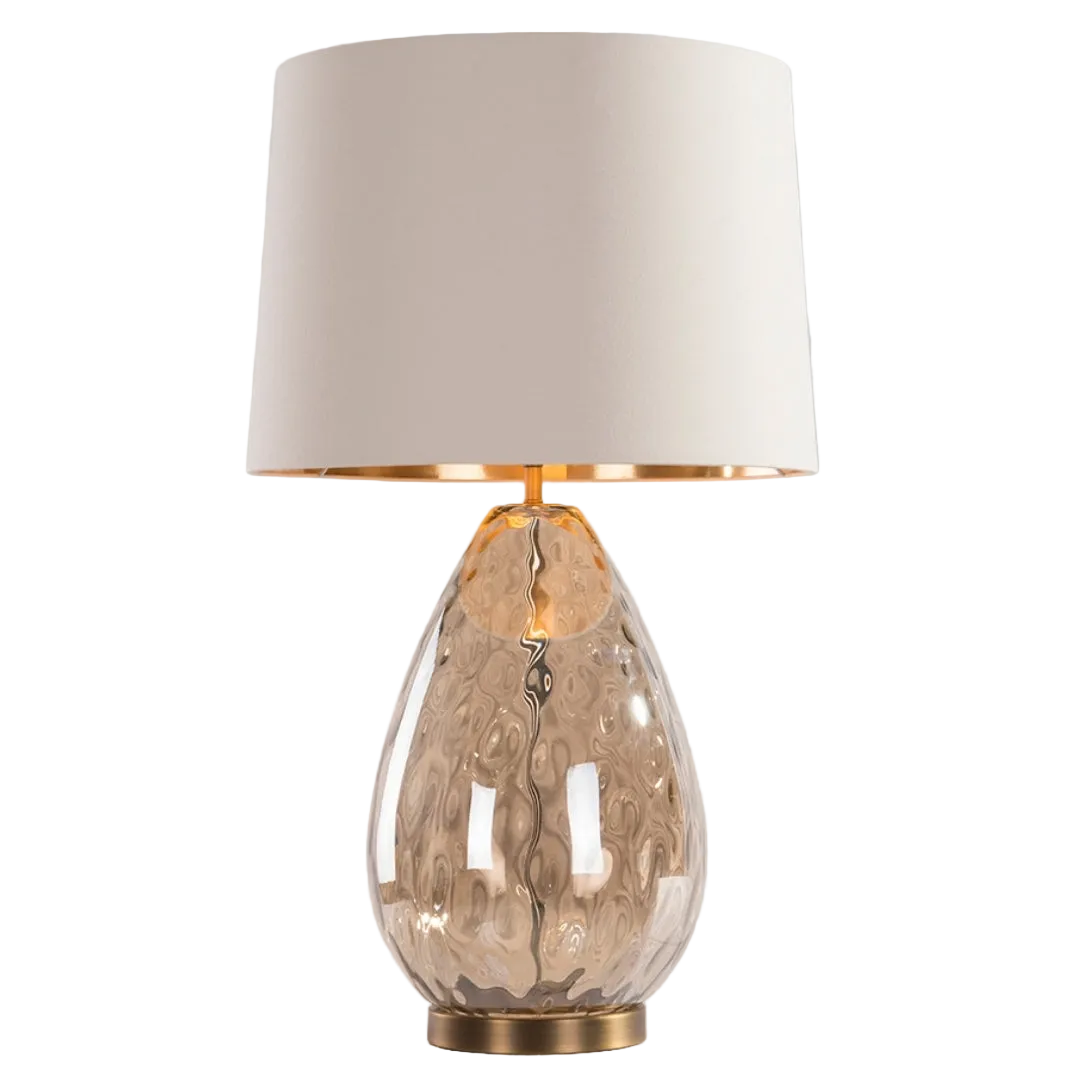 An Oris Table Lamp with a cognac glass base, antique brass detailing, and an opal fabric shade.