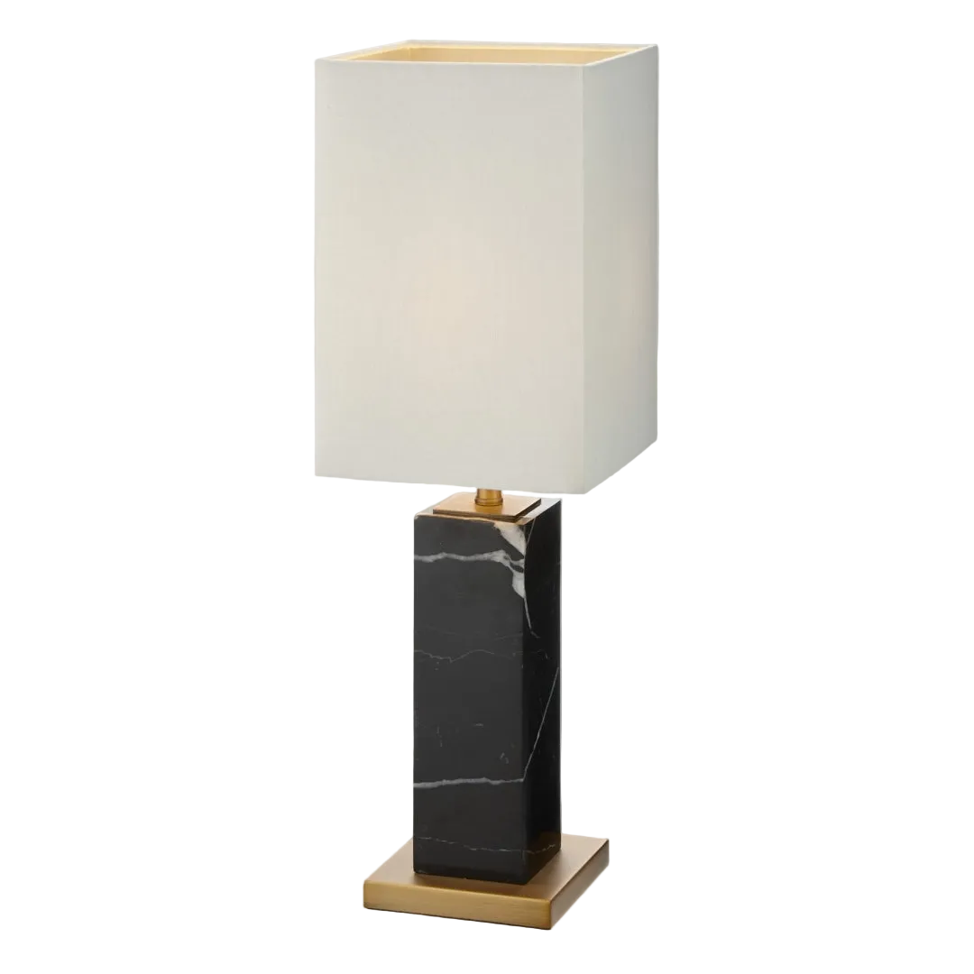 A petite table lamp with a black marble base and antique brass accents, topped with an opal fabric shade.