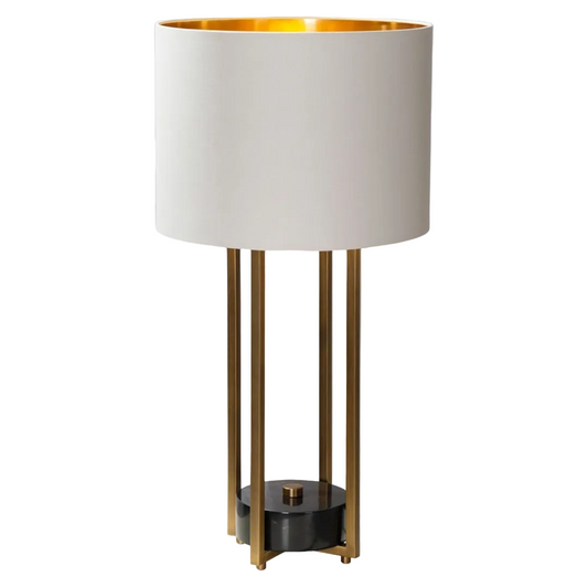 A table lamp with a white fabric shade, antique brass base and black accents.