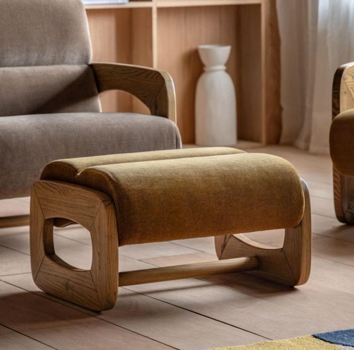 Brown footstool with wooden legs in a living room setting