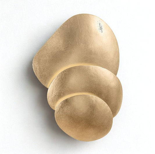 A modern abstract wall sconce featuring three organic, overlapping metallic gold discs on a clean white background.